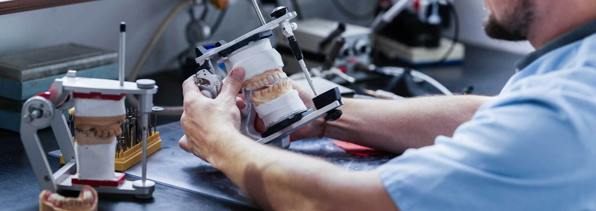 Zahntechniker arbeitet im Dentallabor an einem Kiefermodell Zahntechniker arbeitet im Dentallabor an einem Kiefermodell