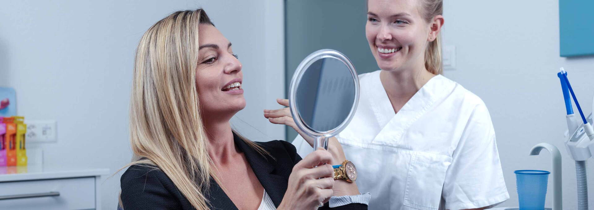 Patientin freut sich mit Dentalhygienikerin vom Dentalhygiene-Team Patientin freut sich mit Dentalhygienikerin vom Dentalhygiene-Team