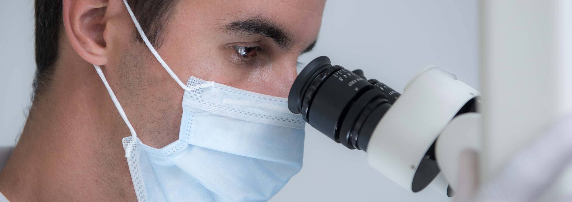 Zahnarzt blickt ins Dentalmikroskop Zahnarzt blickt ins Dentalmikroskop