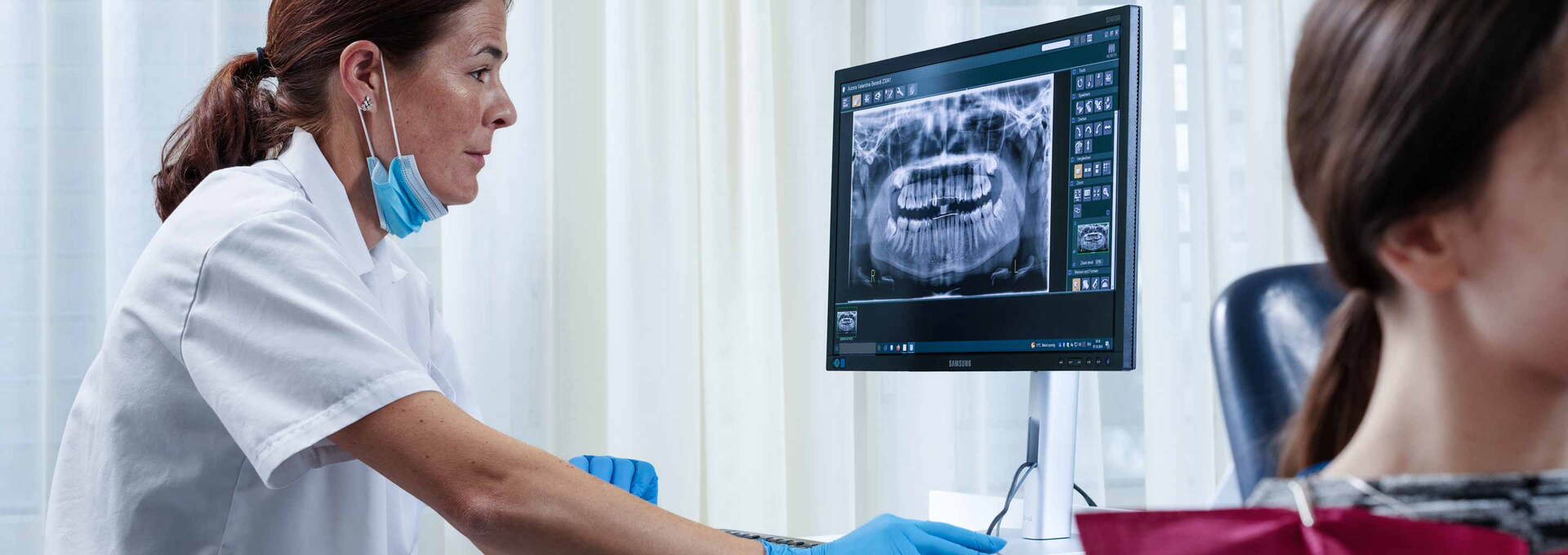 Zahnärztin analysiert Orthopantomogramm einer Patientin Zahnärztin analysiert Orthopantomogramm einer Patientin